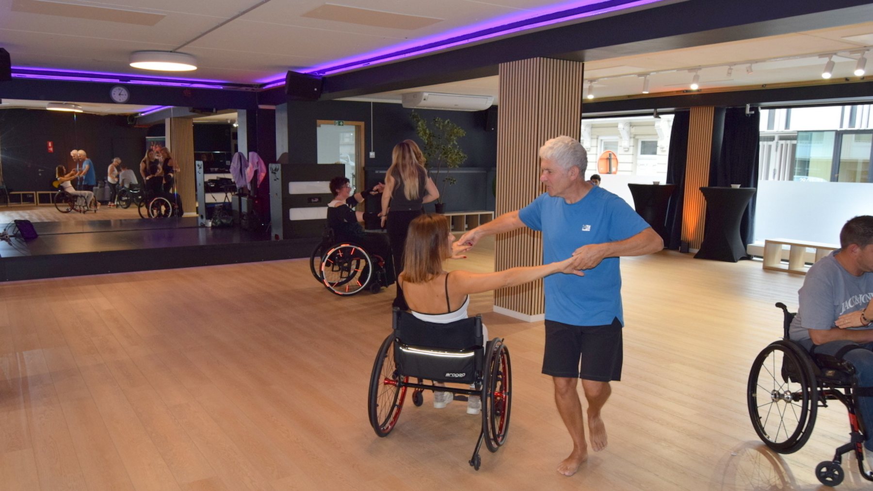 A cyclodance class at Studio 28: dancers in wheelchairs and standing, together on the oak floor