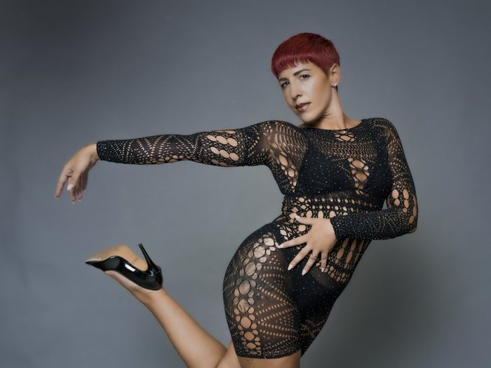 Elena, heels teacher, in a black dress and heels