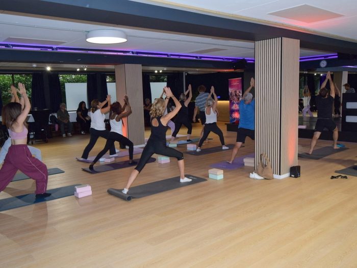 Yoga class on mats, standing pose, daylight