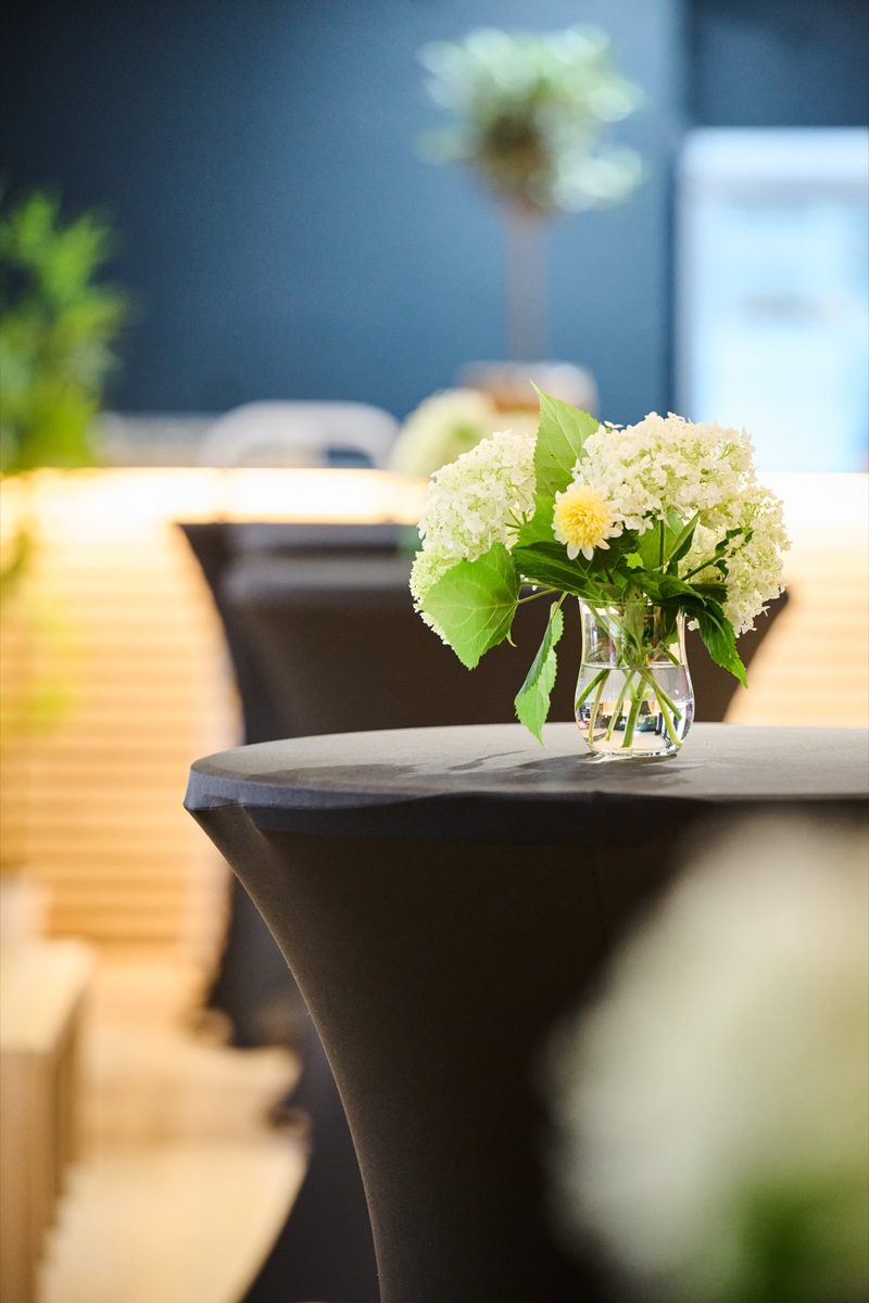 White flowers on a high table, charcoal wall behind
