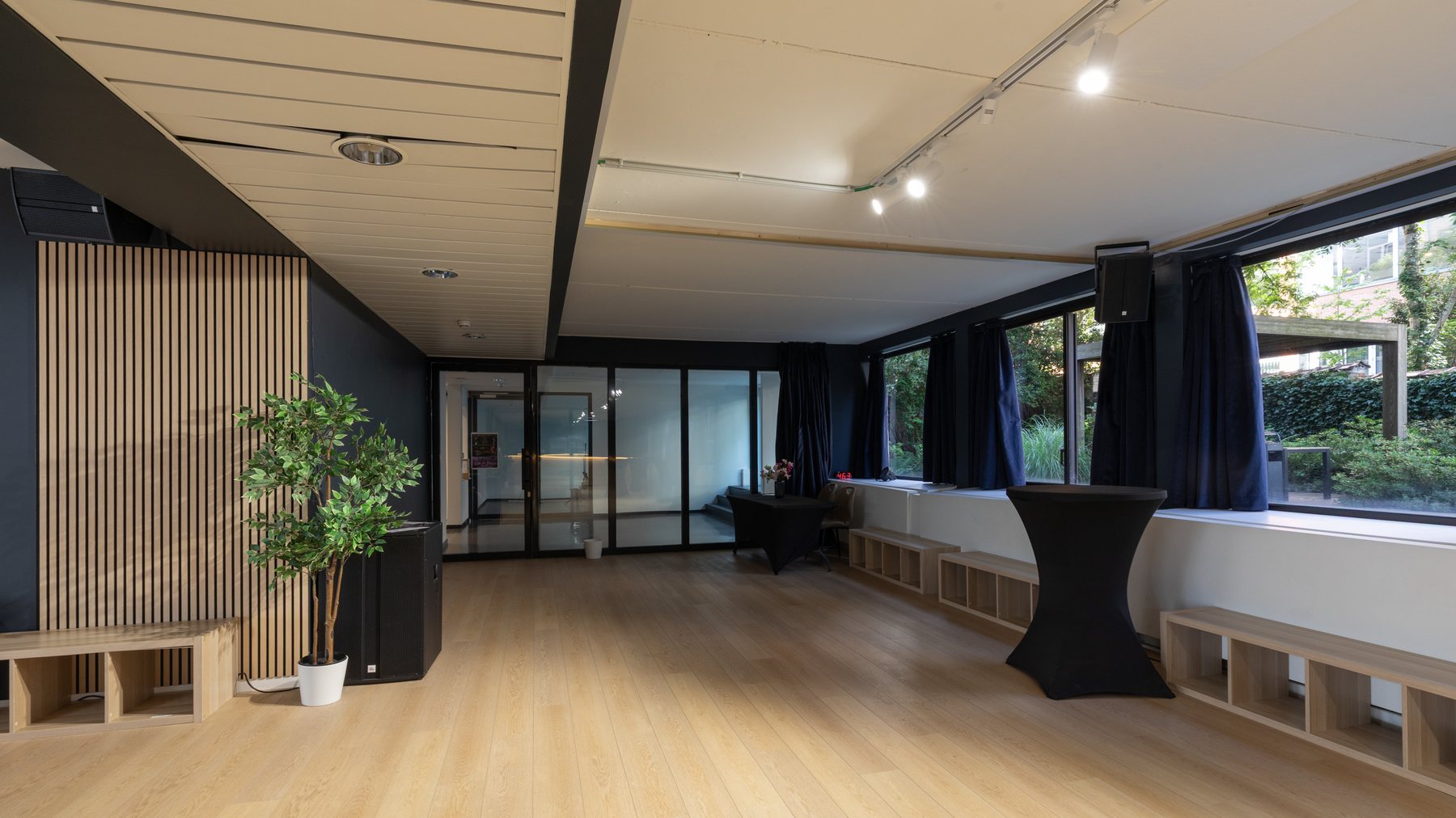 The main room at Studio 28, pale oak floor and glass doors onto the garden